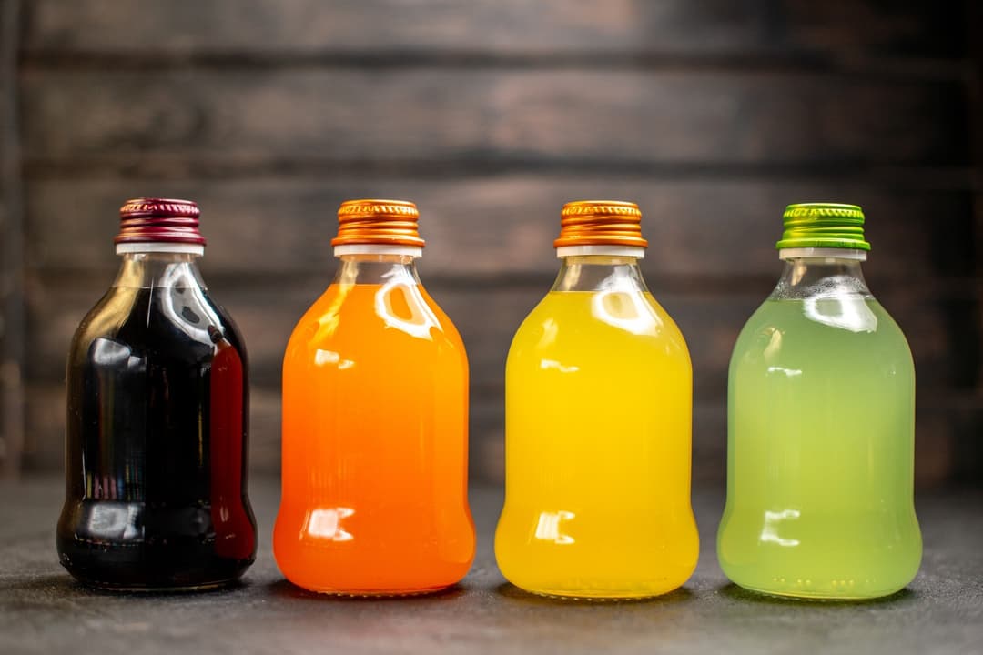 front-view-black-orange-yellow-green-fruit-juice-bottles_140725-99674