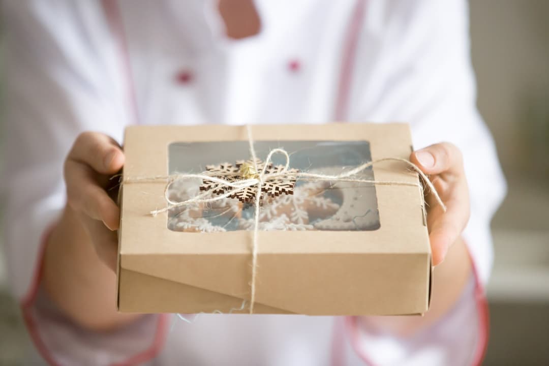 hands-holding-out-box-with-collection-christmas-cookies_1163-2865