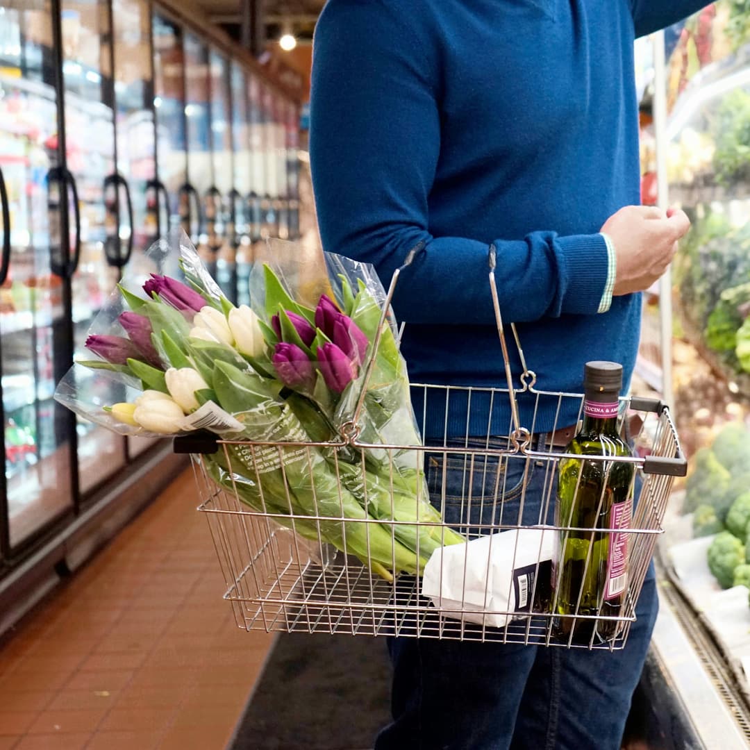 Person with olive oil in shopping basket